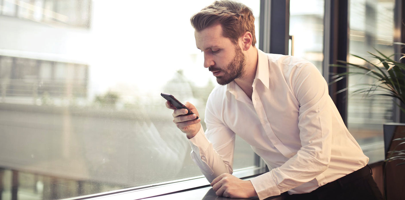 man-in-office-looking-at-phones